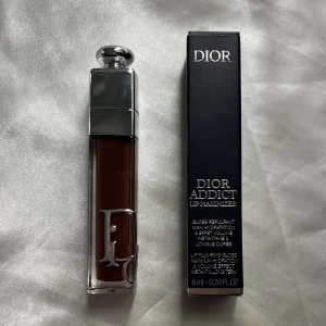 Dior Addict Lip Maximizer (020 MAHOGANY) - Säljer ett Dior Addict Lip Maximizer läppglans i färgen 020 MAHOGANY Lyxig förpackning med silverdetaljer och stor Dior-logga på framsidan. Ger plumpande effekt och intensiv glans, kommer i en elegant svart kartong. Innehåller 6 ml.
