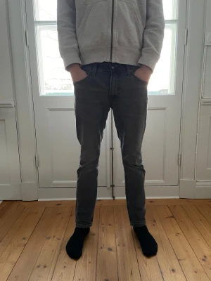 Lee Jeans Slim fit - Säljer ett par grå jeans från Lee med klassisk femficksdesign och raka ben. Jeansen har Slim passform och är tillverkade i mjukt denimtyg. Snygg, enkel look med diskreta sömmar och Lee-logga på bakfickan. Storleken är W30 L30