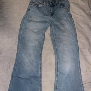 Ljusblå bootcut jeans XS från 157 - Ljusblå jeans från 157 i bootcut-modell med full längd. Byxorna har klassisk femficksdesign och råa, slitna benslut för en avslappnad vibe. Tillverkade i jeansmaterial och passar perfekt för dig som gillar en lite vidare passform nertill.