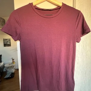 Vinröd t-shirt från 157, stl S - Enkel och stilren vinröd t-shirt från 157 i storlek S. Klassisk rund halsringning och korta ärmar. Perfekt basplagg i garderoben och lätt att matcha med allt. Mjuk och skön känsla.
