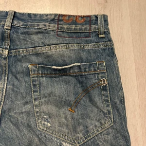 Dondup jeans - Ett par riktigt snygga dondup jeans. Jeansen har många slitningar längst med benen både på framsidan och på baksidan. Det är storlek 33 i midjan med de är rätt små så jag skulle säga att det är mer som 32. Jeansen har en grymt snygg tvätt och knappgylf och de sitter slim. Tveka inte på att höra av er om frågor eller om ni vill ha fler bilder eller mått. Priset är såklart inte hugget i sten så kom gärna med prisförslag!