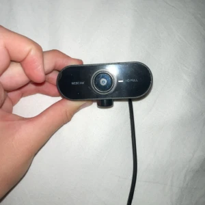 HD Full USB Webcam - En kompakt HD Full USB-webbkamera med inbyggd mikrofon. Enkel att ansluta via USB och passar perfekt för videomöten och streaming. Kameran är i gott skick med mindre ytliga repor, inga synliga skador. Fungerar med de flesta datorer. Kamera till att streama funkar på Xbox ps och pc knappt använd väldigt bra kvalitet bara att under delen som man behöver till att sätta upp den är borta men den kan stå ele så kan man sätta fast den ordinal priset var 450kr