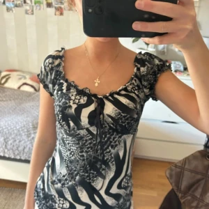 Svartvit zebra-mönstrad blus med snörning - Säljer en snygg blus med svartvitt zebramönster och coola detaljer. Använd få gånger och inga defekter!! 