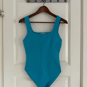 Turkos bodysuit från Zara - Snygg turkos bodysuit från Zara med breda axelband och fyrkantig halsringning. Oanvänd 🩵