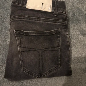 W30 L30 Svarta slim jeans från T/J (Style:evolve) - Säljer ett par svarta slim jeans från T/J med klassisk femficksdesign och snyggt tvättad finish. Jeansen är i bra skick och är i storlek 30 30. Levererar inom 1 dag!🚚