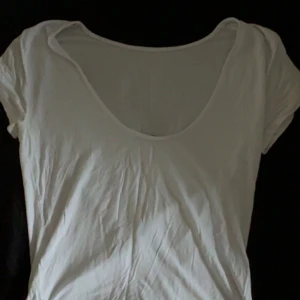 Vit kortärmad linnetopp - En enkel och fräsch vit linnetopp med rundad, urringning i ryggen och korta ärmar. 
