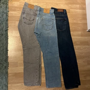 Jeans  - Jag säljer 3x super snygga jeans. Ett mörkblått par slim fit jeans från dressmann storlek 33/30. ett par ljusblå straight jeans från dressmann. Ett par ljusblå straight fit jeans från Jack & Jones storlek 30/32. Till sist ett par ljusgrå jeans med samma passform som de ljusblå också storlek 30/32. Alla dessa jeansen är fina och tidlösa modeller som passar perfekt till uppklätt men även fin vardags stil. (Ljusblå saknar knapp nr2 uppefrån) alla för 199:- eller 99:-st.