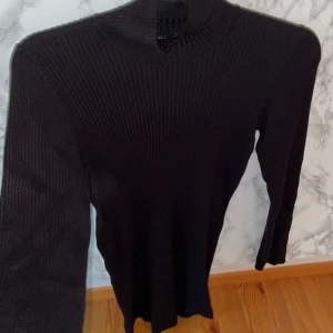 Svart ribbad stickad klänning - Når ungefär ovanför knät