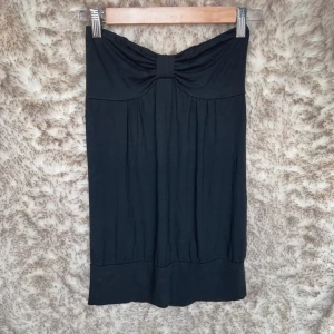 Svart tubtopp  - Söt svart tubtopp med fin detalj på bröstet.  Stretchigt och skönt material. 