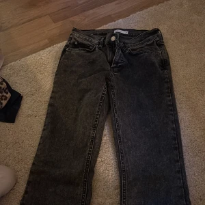 Svarta jeans från Perfect Jeans, stl 36 - Snygga svarta jeans från Perfect Jeans i storlek 36. Jeansen har en tvättad look, raka ben och klassiska fem fickor. Perfekta för dig som gillar en enkel men cool stil. Materialet är jeans och färgen är mörkgråsvart.