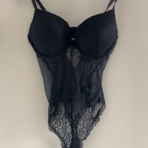 Svart spetskorsett från H&M 85C - Säljer en väldigt populär svart korsett från H&M i storlek 85C. Den har vacker spets med blommönster, meshdetaljer och justerbara axelband. Kuporna är vadderade och ger snygg form. Perfekt för dig som vill ha en feminin och edgy look.