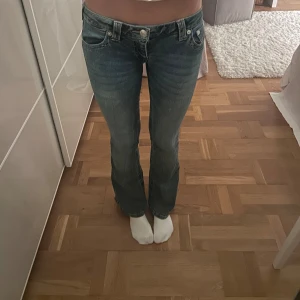 True Religion ultra low waist bootcut  - Säljer true religion jeans ultra low waist bootcut. Använd fåtal gånger och är i bra skick. Storlek 26 köpta på Nelly för 1199kr. 