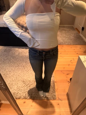 Vit offshoulder långärmad topp - Trendig vit offshoulder topp med långa ärmar och tight passform. Toppen har en stilren, minimalistisk look och är perfekt för dig som gillar en enkel men snygg stil. Tillverkad i mjukt material som sitter skönt mot kroppen.