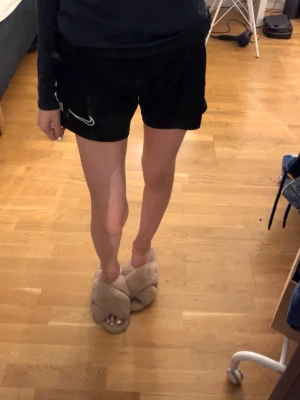 Svarta Nike shorts med vit detalj - Svarta Nike shorts med vit rand, andvänt nån gång hemma, 