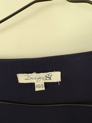 Mörkblå omlottopp från Design by Si - Mörkblå långärmad topp från Design by Si med omlottdesign och knyt framtill. Jätte fin tröja i bra skick. 