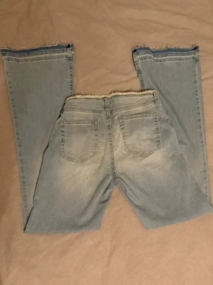 Ljusblå bootcut jeans no waist🤍 - Säljer ett par ljusblå bootcut jeans med fransiga, kanter i midja. Jeansen har klassisk femficksdesign och är tillverkade i mjukt denimtyg. Jag har sytt in i midjan på ena sidan ca 3-5 cm. Jag säljer då de är för stora🤍 Endast använt vid fåtal tillfällen och har inga märken på användning . Om ni har några frågor tveka inte på att höra av er🤍