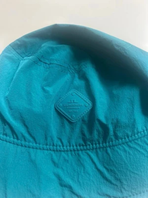 Turkos bucket hat från J.Lindeberg - Snygg turkos bucket hat från J.Lindeberg med diskret logga framtill. Nypris 400kr💕