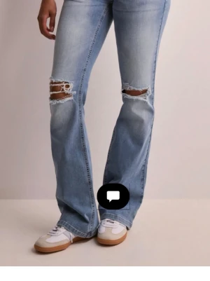 Ljusblå bootcut jeans med slitningar - Snygga ljusblå jeans med bootcut-modell och slitna detaljer vid knäna. Jeansen har klassisk femficksdesign och stängs med knapp och dragkedja. Perfekta för dig som gillar en avslappnad och trendig look. Köpta för 800 och är helt slutsålda på hemsidan. 