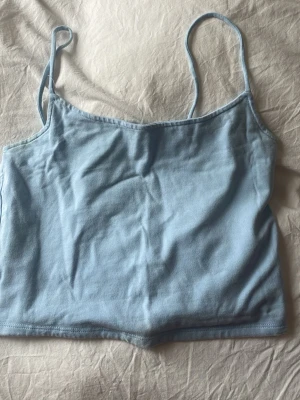 Ljusblå linnetopp från FB Sister - Säljer en ljusblå linnetopp från FB Sister i storlek M. Toppen har smala axelband och är croppad i modellen. Perfekt till sommaren och enkel att matcha med jeans eller kjol.