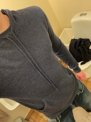 Mörkblå hoodie från John Henric - Mysig mörkblå cashmerehoodie från John Henric med dragsko i huvan och känguruficka framtill. Tillverkad i mjukt material som känns skönt mot huden. Perfekt för en avslappnad och stilren look.