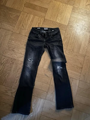 Svarta bootcut jeans med slitningar - Snygga jeans från LTB med slitningar på båda benen och lätt tvättad look. Klassisk femficksmodell med  låg midja. Perfekta för en avslappnad och trendig stil.  L:32 W:26