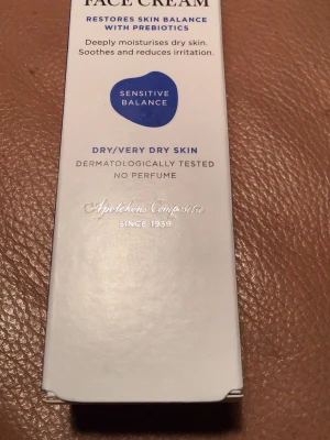 Face Cream Sensitive Balance 50 ml - Ansiktskräm för torr till mycket torr hud från Apotekens Composita. Innehåller prebiotika och vitamin E som återfuktar, lugnar och stärker huden. Dermatologiskt testad och parfymfri. Förpackningen är vit med blå detaljer och rymmer 50 ml.