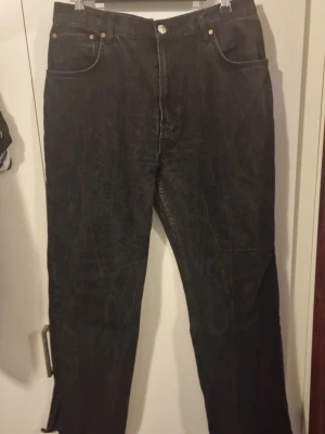 Svarta raka jeans från Gina tricot  - Klassiska svarta jeans från Gina Tricot med raka ben och femficksmodell. Jeansen har knapp och dragkedja framtill samt bälteshällor. Perfekta för en stilren och enkel look.