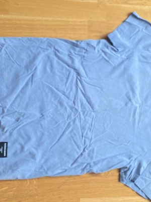 Blått loungset från Björn Borg  - Mysigt loungset från Björneborg  i ljusblått. Setet består av en t-shirt med kort ärm och ett par shorts med dragsko och fickor. Båda plaggen har en liten svart Calvin Klein-logga. Perfekt för chill hemma eller som sovplagg. Ett litet hål på sidan som man knappt ser 