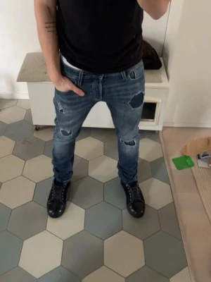 Jack and Jones - Säljer ett par riktigt feta jeans från Jack and Jones med slitningar. Modellen är Slim Glenn