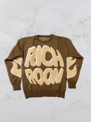 Stickad RichRoom tröja - Brun stickad tröja med texten rich room. Färgen på den här stickade tröjan är brun/ beige. Väldigt skön och mjuk i materialet, bekväm passform med rund hals och ribbade muddar. Aldrig använd, i nyskick. Storlek passar som S.