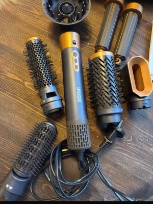 Multistyler med tillbehör - Säljer en multistyler  i svart och kopparfärg. Setet innehåller flera utbytbara borsthuvuden, locktillbehör, volymmunstycke och diffuser. Perfekt för att skapa olika frisyrer. Medföljer även en svart förvaringsväska och instruktionsbok. Den är testad en gång 