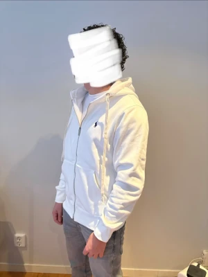 Vit zip hoodie från Ralph Lauren - Snygg vit hoodie med dragkedja från Ralph Lauren. Klassisk design med huva och dragsnören, samt den ikoniska lilla loggan broderad på bröstet. Ny!