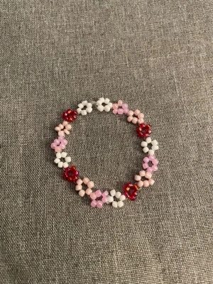  pärlarmband med blommor storlek S  - handgjort pärlarmband gjort av pärlor i vitt, rosa, rött och ljusrosa. 