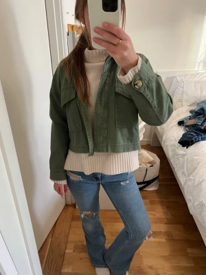 Blå slitna bootcut jeans - Säljer ett par blå bootcut jeans med slitningar på knäna och låren. Jeansen har en klassisk femficksmodell och normal passform. Perfekta för dig som gillar en avslappnad och trendig stil.