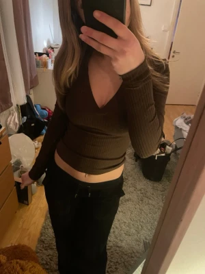 Brun ribbad v-ringad topp - Helt ny snygg brun långärmad topp med v-ringning och ribbad struktur.Bara provad men säljer pga fel storlek, lappar finns kvar! 