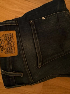 Replay jeans - Snygga mörkblå jeans från Replay med coola slitningar. Jeansen har en läderpatch med Replay-logga bak och raka ben. Perfekta för en avslappnad och trendig stil. Pris kan diskuteras!