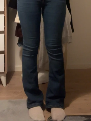 Blå bootcut jeans med låg midja - Säljer dessa snygga blåa bootcuten jeansen i storlek 34 från Gina. Jag är 159 och har sytt upp dom så att de ska passa mig så passar nog 157-161. Säljer pga att de är liite för tajta för mig och kommer inte till användning