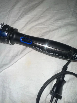 Björn Axén Tools varmluftsborste - Säljer en svart varmluftsborste från Björn Axén Tools med blå detaljer och keramisk borste. Perfekt för att styla håret med volym och form. Borsten har sladd och knapp för olika värmelägen. Enkel att använda för snygg frisyr. Original pris 799kr