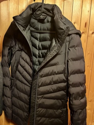 Svart dunjacka - Snygg svart, tunn pufferjacka med quiltad design. Jackan har dragkedja, även två fickor med dragkedja. Den är lätt vadderad för extra värme. Perfekt för kalla dagar och enkel att matcha med olika outfits.