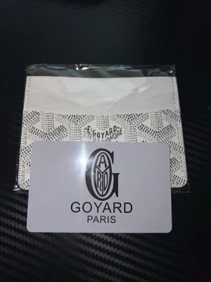 Plånbok vit  - Snyggt vitt kortfodral med deras ikoniska mönster och logga framtill. Smidig och stilren design med flera kortfack, perfekt för att hålla ordning på dina kort. Tillverkat i exklusivt material med lyxig känsla. Priset är ej hugget i sten vid snabb affär och endast seriösa köpare! 