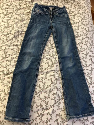 Blå low waist  bootcut jeans med vita sömmar - Snygga blå bootcut jeans med kontrasterande vita sömmar och klassiska fem fickor. Jeansen har normal passform och är tillverkade i mjukt denimtyg. Perfekta för en avslappnad och trendig look.