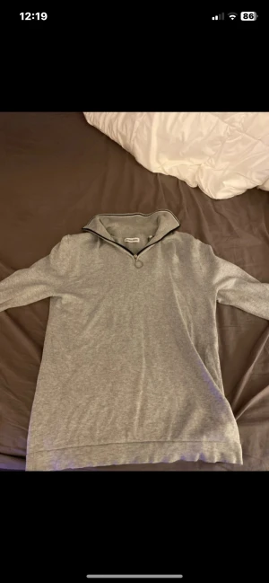 Grå half zip tröja Jack & Jones XS - Snygg grå långärmad tröja från Jack & Jones i storlek XS. Tröjan har en ribbad krage med svart kant och half zip-dragkedja framtill. Mjuk och skön bomullsmix som passar perfekt när det är lite kyligt ute. Tröjan fungerar bra som storlek S också!