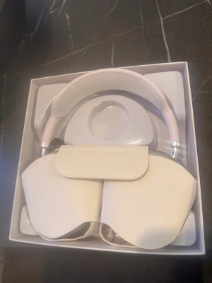 AirPods Max - Apple AirPods Max i silver, over-ear trådlösa hörlurar med aktiv brusreducering. Komplett med originalförpackning och skyddsfodral. Hörlurarna ser ut att vara i mycket gott skick utan synligt slitage eller repor. Perfekt för musik, film och samtal med hög ljudkvalitet.