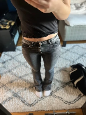 Grå bootcut jeans från Grunt Jeans  - Snygga grå jeans från Grunt Jeans med tvättad look och klassisk femficksdesign. Modellen har bootcut-ben och normal passform, med knapp och dragkedja framtill. 