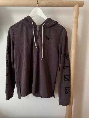 Mörklila hoodie från PINK XS - Snygg mörklila hoodie från PINK med halv dragkedja, huva och vita snören. Långärmad med tryck på ärmarna och liten hundlogga på bröstet. Mjuk bomullskänsla. 