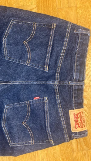 Levi's Loose Taper jeans mörkblå - Mörkblå jeans från Levi's med klassisk femficksdesign, tydliga kontrastsömmar och patch bak. Modellen är Loose Taper med avslappnad passform och avsmalnande ben. Tillverkade i robust denim med knappgylf och Levi's röda etikett på bakfickan.