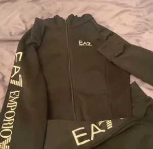 Svarta EA7 Emporio Armani sett  - Säljer ett sett från EA7 Emporio Armani, jätte fint använda typ bara 2,3 gånger säljer då jag inte använder längre tyvärr, koftan ger en väldigt fin form som matchar fint med byxorna 