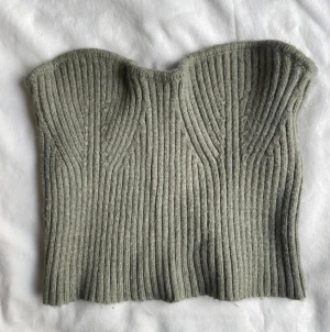 Grågrön ribbad stickad tubtopp - Säljer en grå stickad tubtopp med ribbad struktur och snygg formad överkant. Så himla fin ❤️