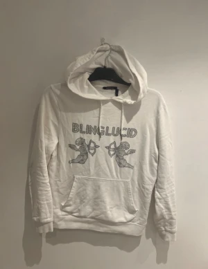 Vit hoodie från Blinglucid med print - Vit hoodie från Blinglucid i storlek XS med coolt print framtill av två änglar och texten BLINGLUCID. Tröjan har huva med snörning och en stor magficka. Perfekt för dig som gillar streetwear och vill sticka ut lite extra.