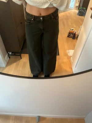 Svarta wide jeans med hög midja - Säljer ett par svarta jeans med riktigt breda ben och hög midja. Klassisk femficksmodell med knapp och dragkedja framtill. Jeansen har en cool, loose passform och är tillverkade i jeansmaterial. De är ifrån hm divided i st 36
